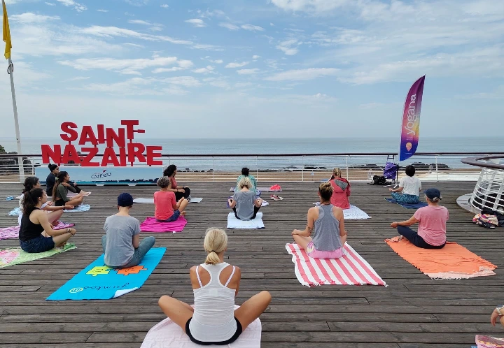 pratique de yoga pieds nus sur la terrasse de la plage de Monsieur Hulot, face à la mer